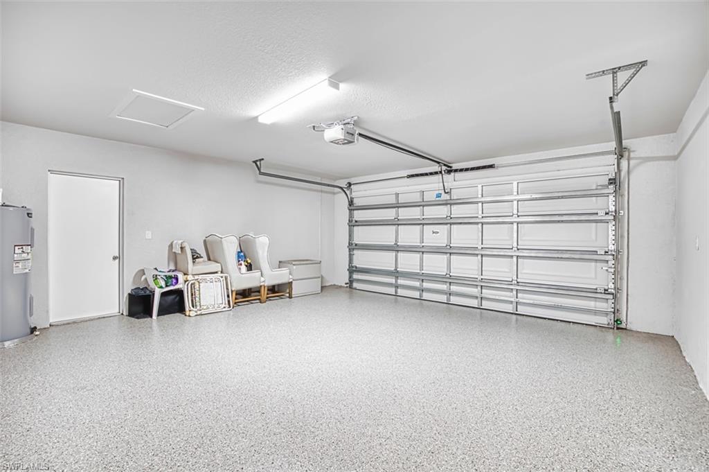 Garage featuring water heater and a garage door opener