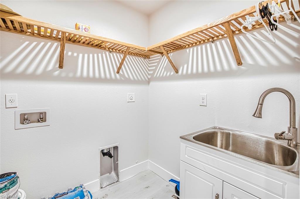 Laundry area featuring light wood finished floors, hookup for a washing machine, and hookup for an electric dryer