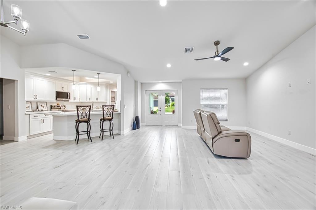 Living area with french doors, light wood-type flooring, ceiling fan, and recessed lighting