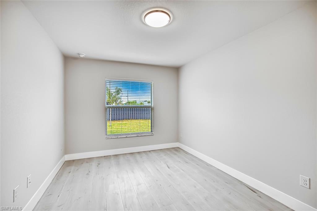 Unfurnished room with light wood finished floors and baseboards