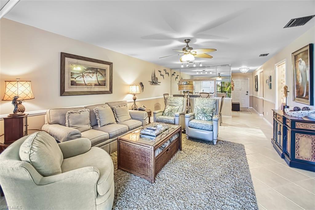 Tiled living area featuring a ceiling fan