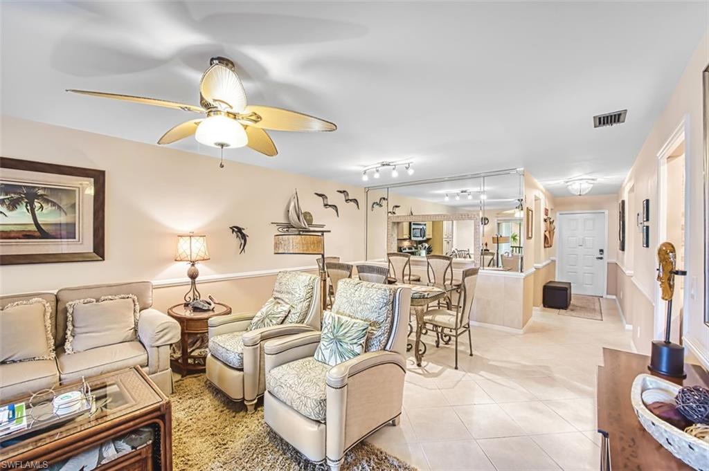 Living area with light tile patterned floors, a ceiling fan, and track lighting