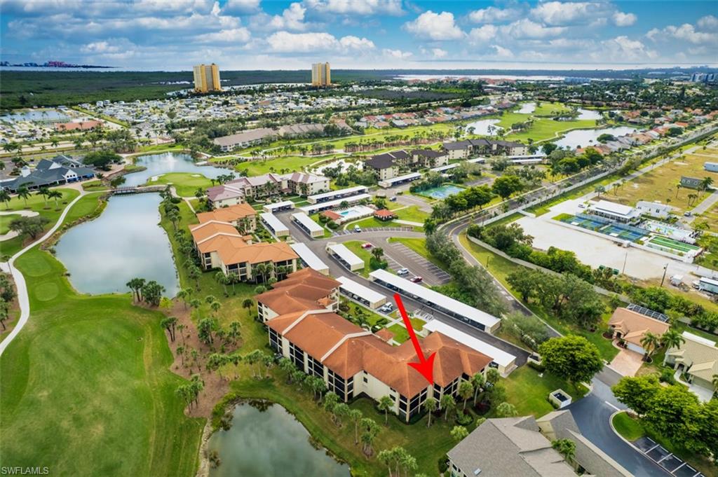 Aerial perspective of suburban area with a nearby body of water and a golf course