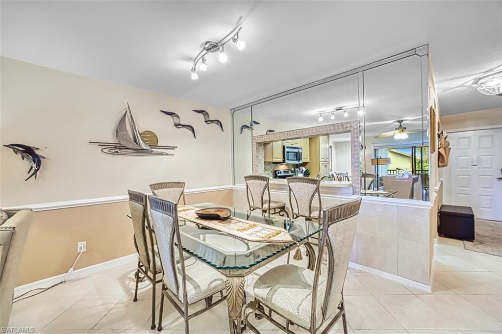 Dining space with a ceiling fan, light tile patterned flooring, and rail lighting