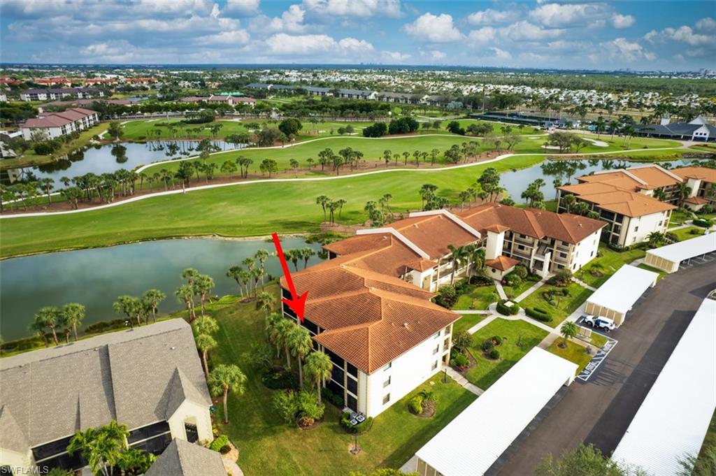 Aerial view of residential area featuring a golf course and a large body of water