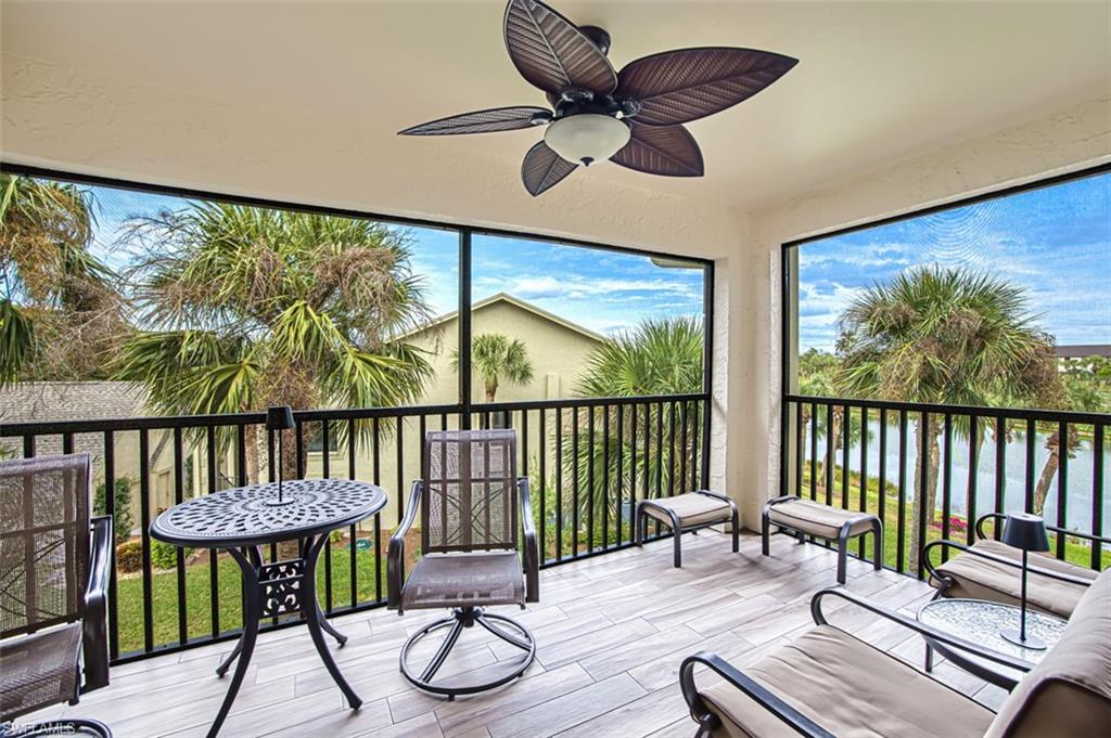 Sunroom / solarium featuring a textured wall, wood finish floors, and a water view