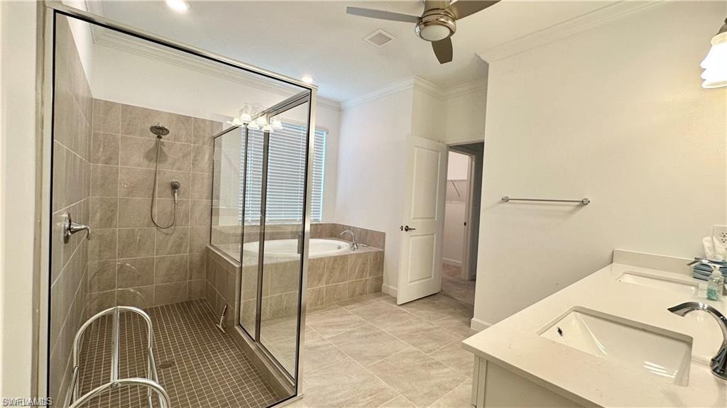 Bathroom featuring ceiling fan, tile flooring, double vanity, and plus walk in shower