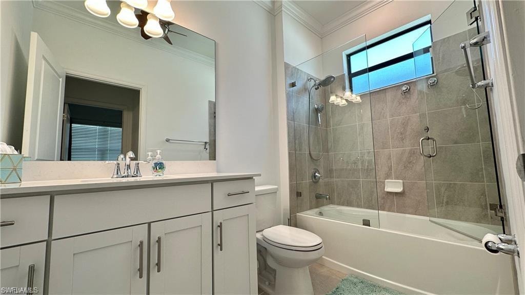 Full bathroom featuring enclosed tub / shower combo, ornamental molding, vanity, and toilet