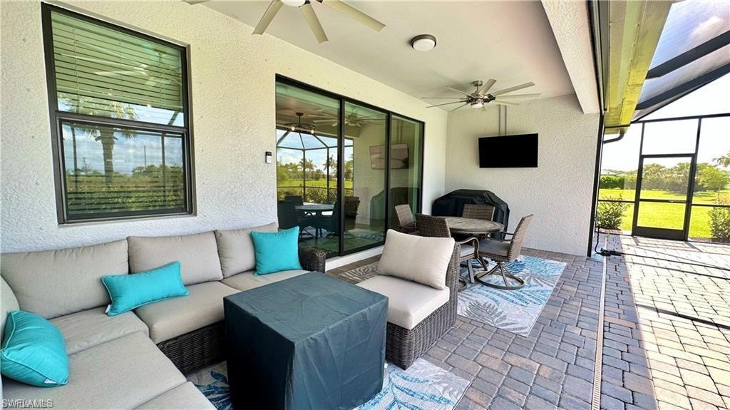View of patio / terrace with glass enclosure, an outdoor hangout area, and ceiling fan