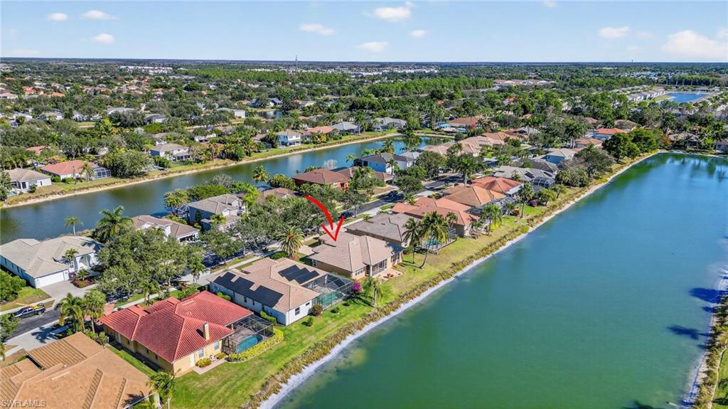 Aerial perspective of suburban area featuring a nearby body of water