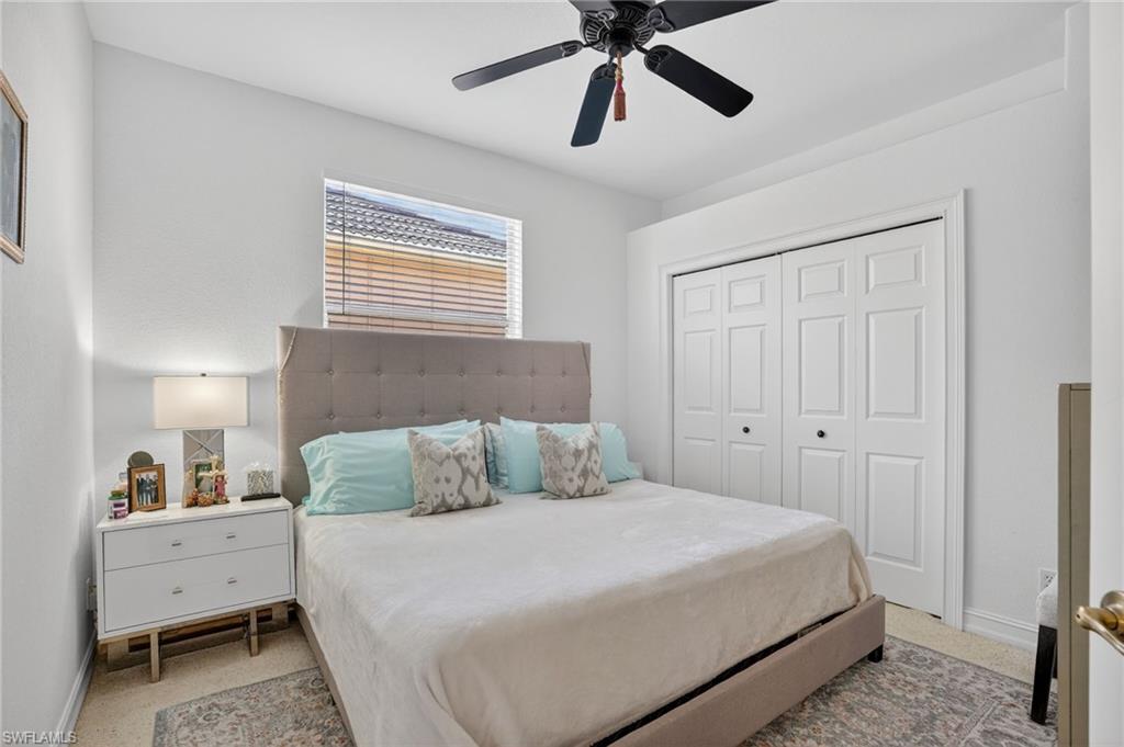 Bedroom featuring ceiling fan, a closet, and light carpet