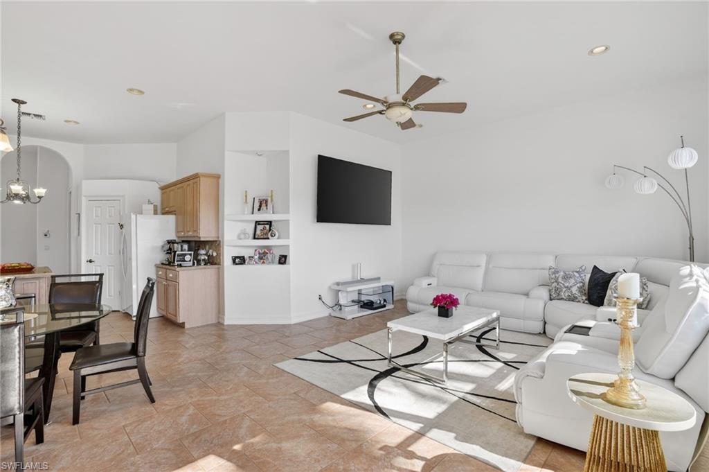 Living area with a chandelier, built in shelves, recessed lighting, and ceiling fan