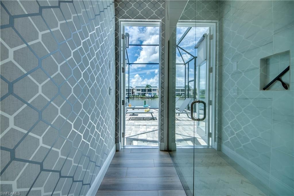 Bedroom featuring wood tiled floors, a closet, and wallpapered walls