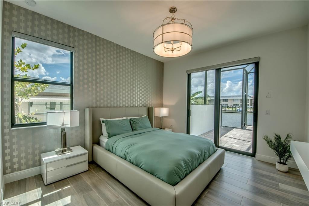 Bedroom featuring wood finished floors, access to outside, and a sunroom
