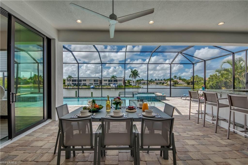 View of patio / terrace featuring a lanai, area for grilling, a ceiling fan, and a sunroom