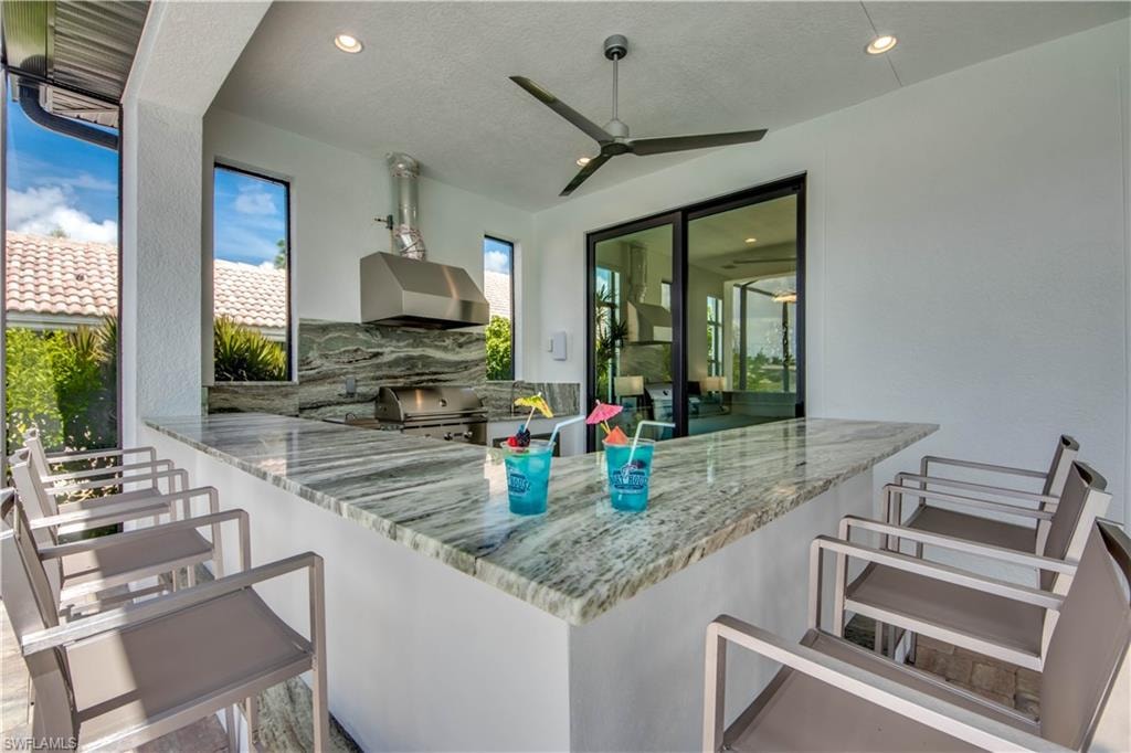 View of pool with a sunroom, glass enclosure, a patio, and a pool with connected hot tub