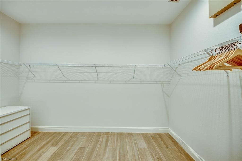 Bathroom with a soaking tub, walk in shower, two vanities, and wood tiled floors