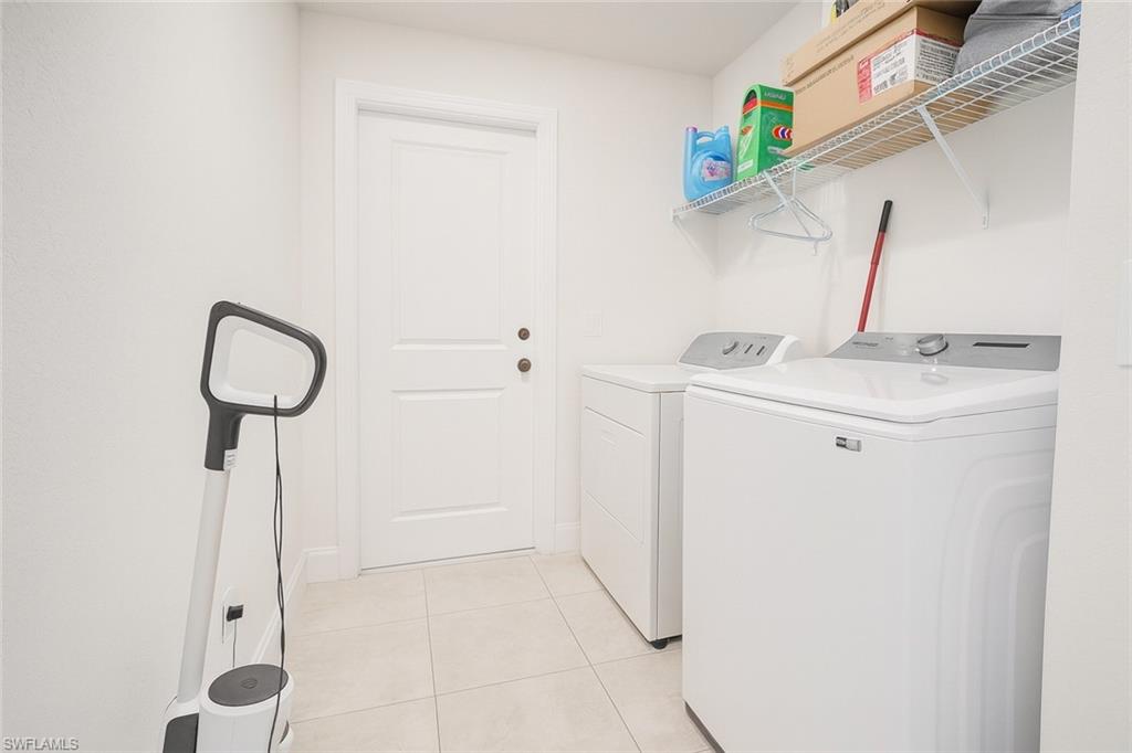 Laundry room featuring washing machine and dryer and light tile patterned flooring