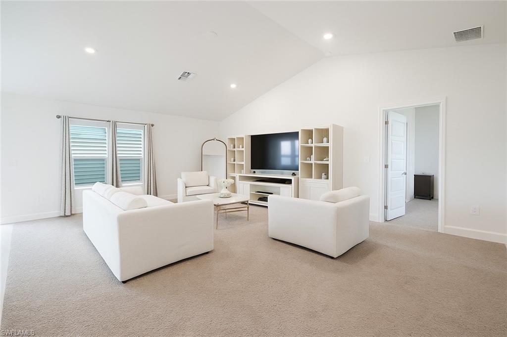 Living room featuring recessed lighting, light carpet, and high vaulted ceiling