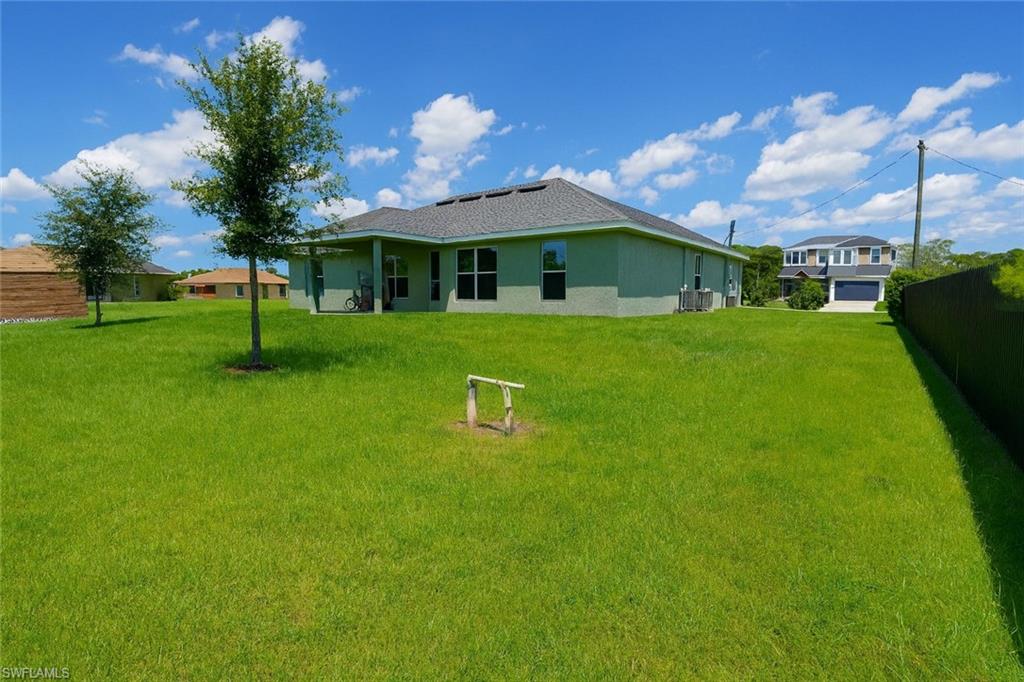 Back of property with stucco siding and a lawn