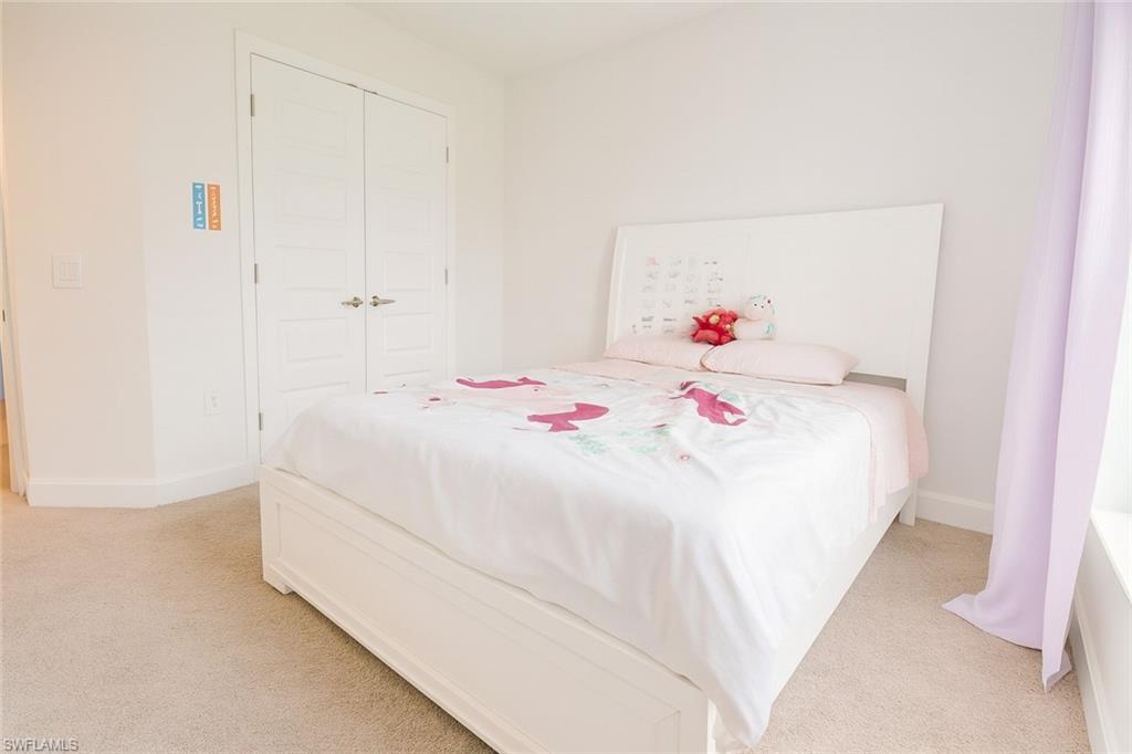 Bedroom featuring light carpet and a closet