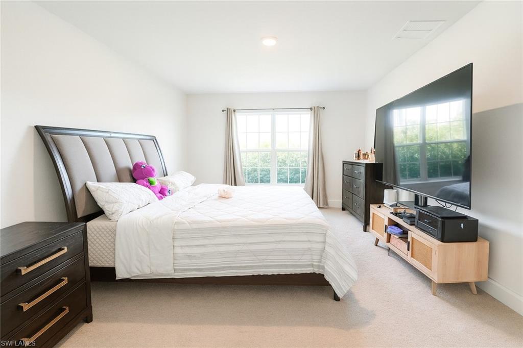 Bedroom with light carpet and baseboards