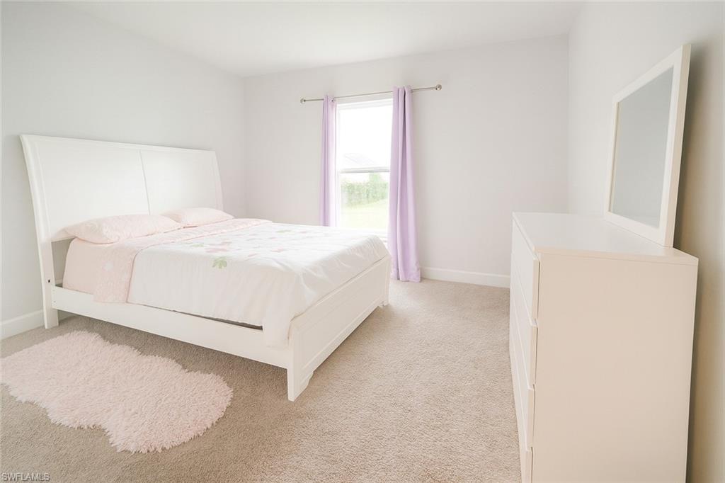Bedroom featuring carpet and baseboards