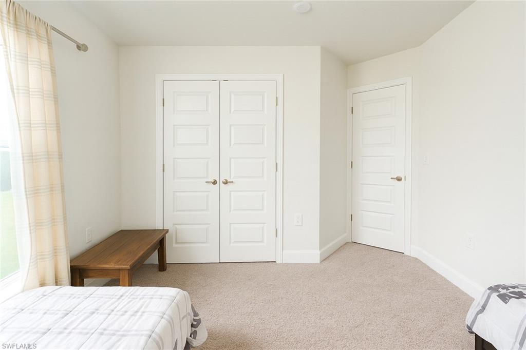 Bedroom featuring light carpet and a closet