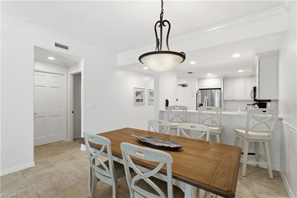 Dining area with ornamental molding, recessed lighting, and light tile patterned flooring