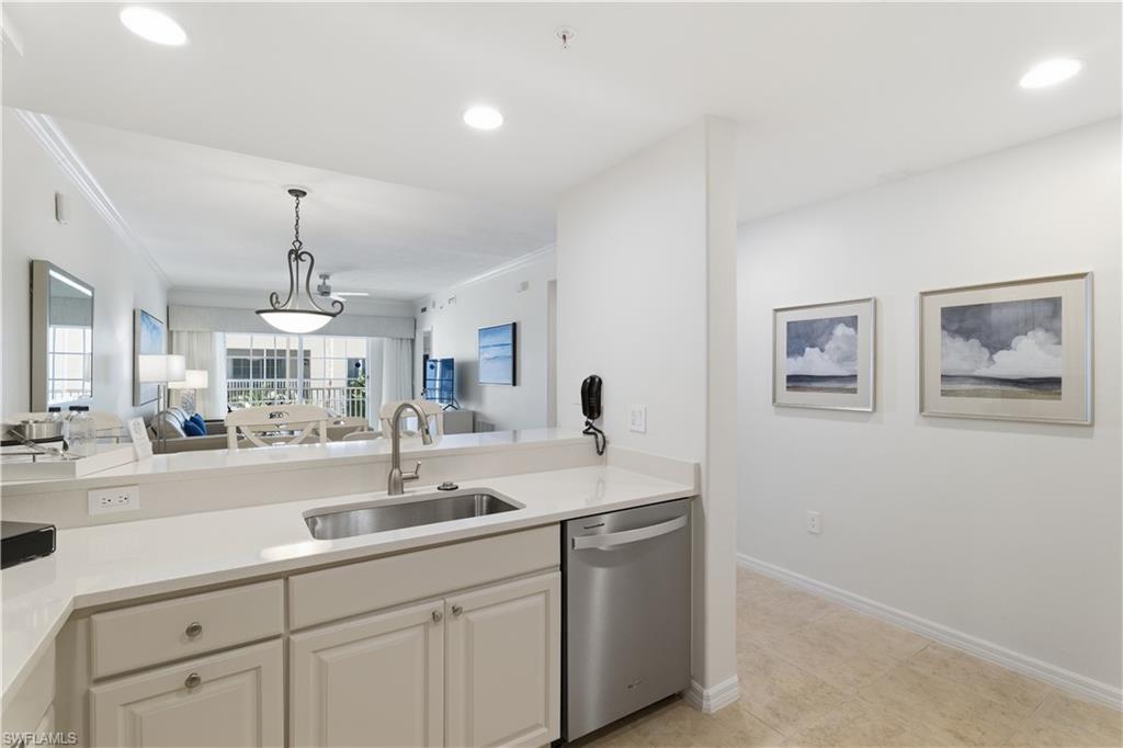 Kitchen with open floor plan, stainless steel dishwasher, light stone counters, pendant lighting, and recessed lighting