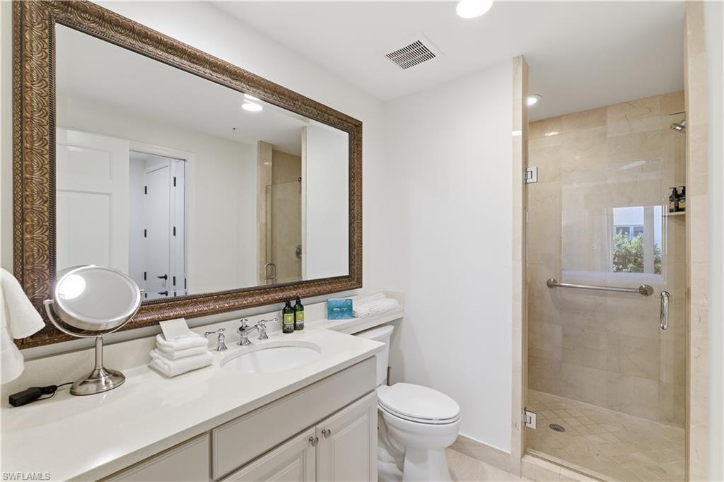 Bathroom featuring a stall shower, vanity, and recessed lighting