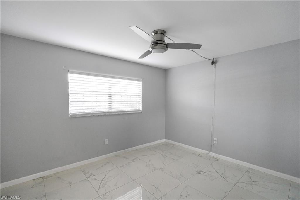 Unfurnished room with light marble finish flooring and a ceiling fan