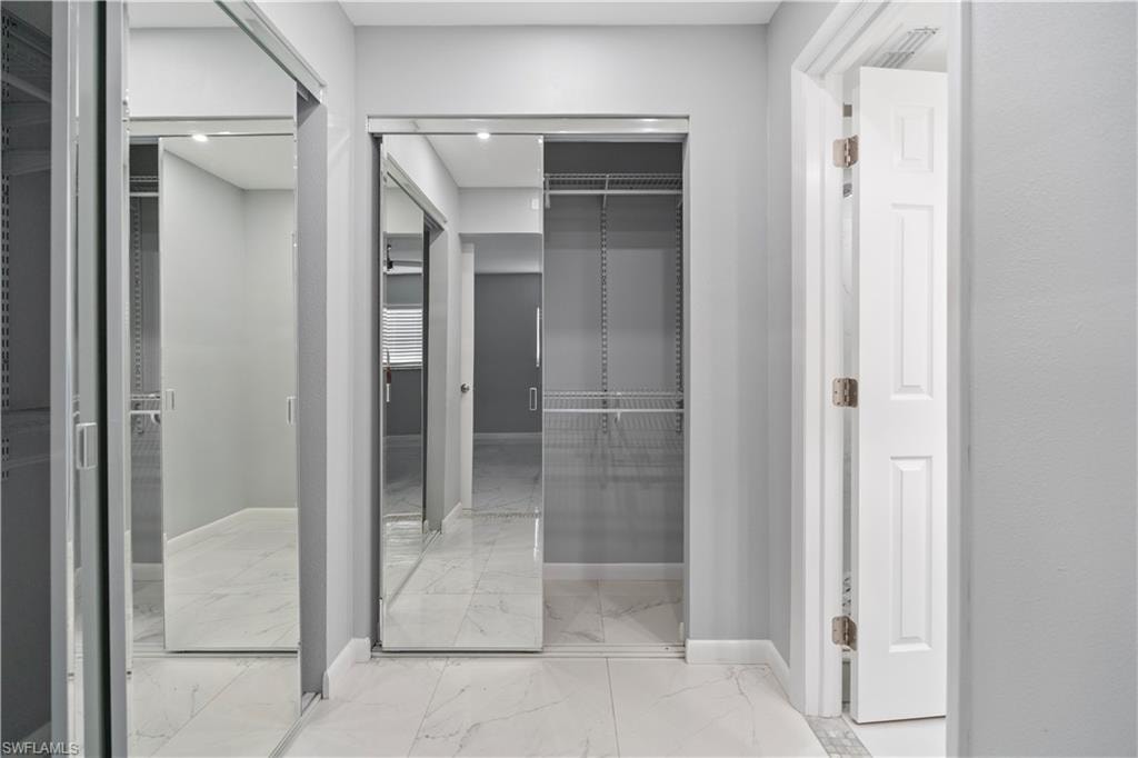 Walk in closet with light marble finish floors