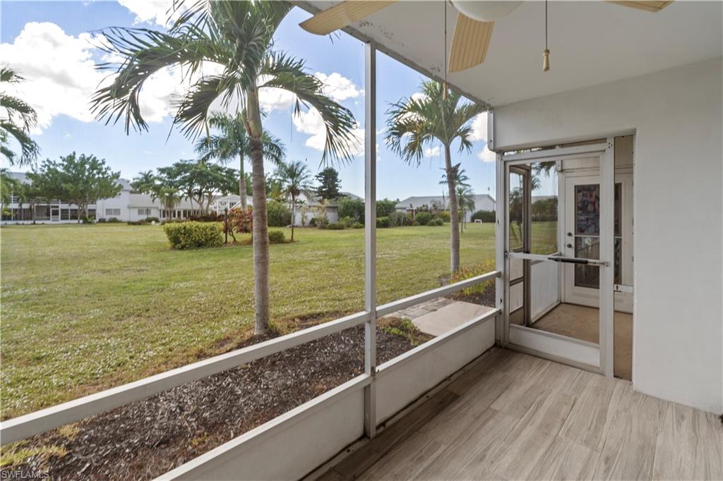 Unfurnished sunroom featuring a ceiling fan and a residential view