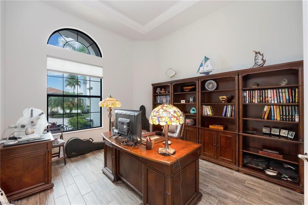 Office area featuring wood tiled floors, ornamental molding, and a tray ceiling