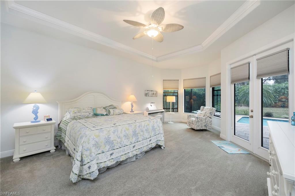 Carpeted bedroom featuring a raised ceiling, a ceiling fan, access to exterior, and crown molding