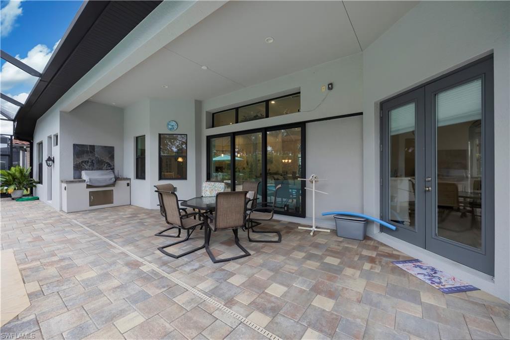 View of patio / terrace featuring a grill, french doors, glass enclosure, and outdoor dining area
