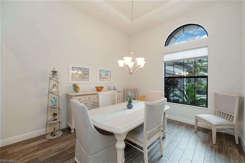 Dining room featuring wood finish floors, a chandelier, and a high ceiling