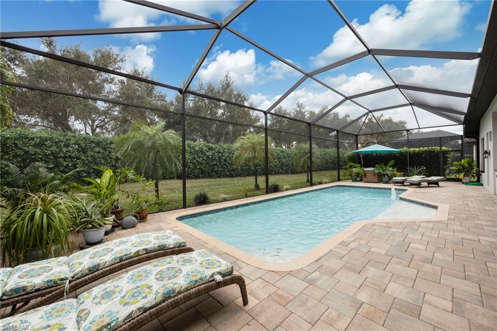 Swimming pool with a lanai, a sunroom, and a patio area