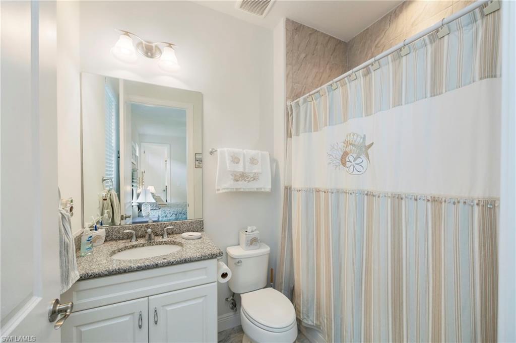 Bathroom featuring a shower with curtain, vanity, and ensuite bath