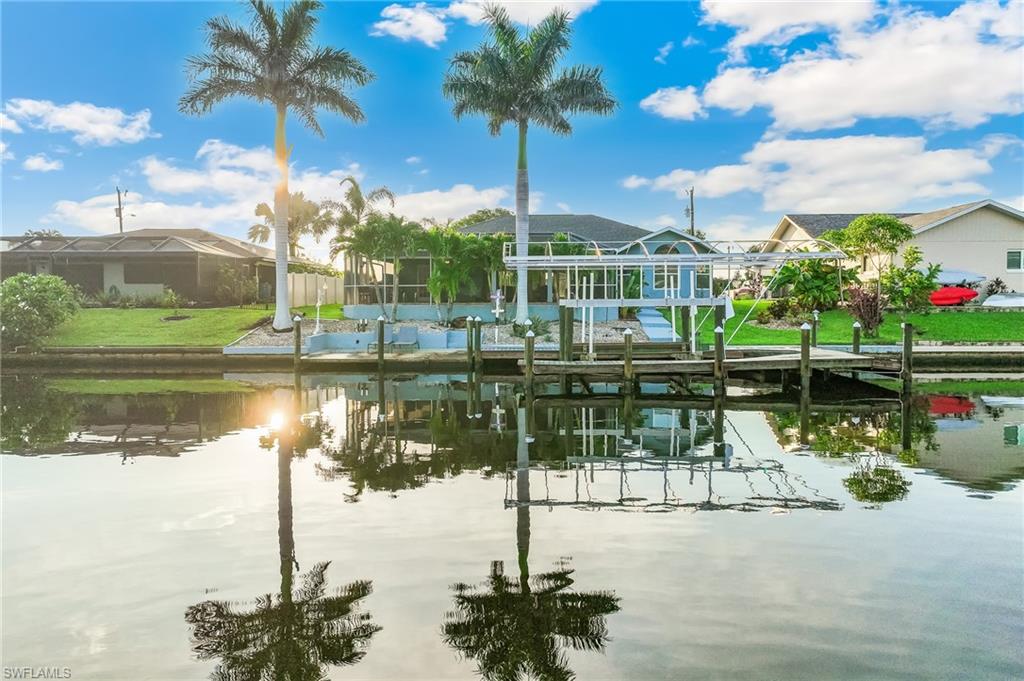 Dock with a water view, boat lift, and a residential view