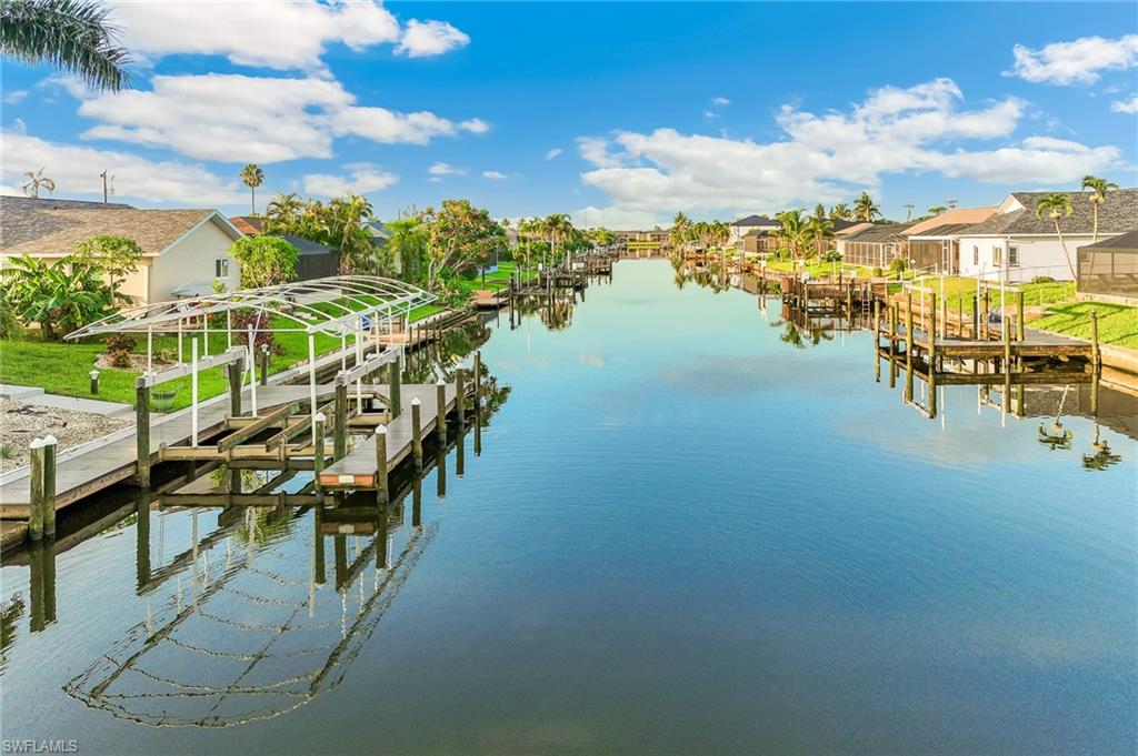 Dock area with boat lift, a residential view, and a water view