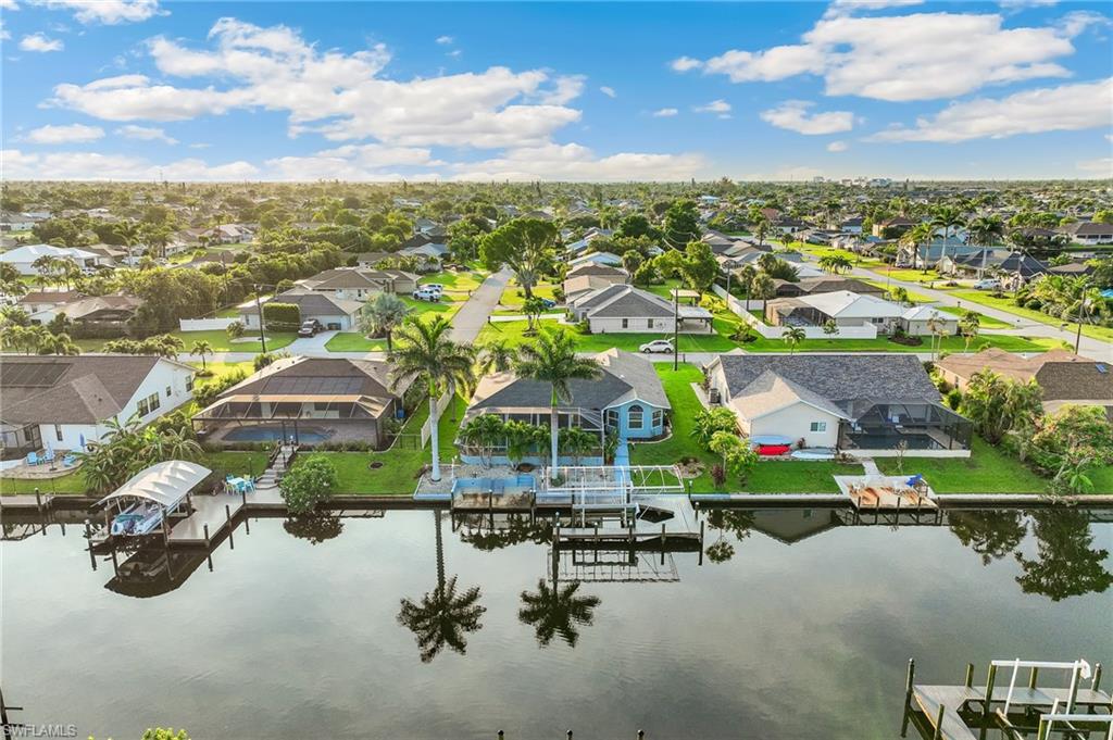 Aerial perspective of suburban area featuring a nearby body of water