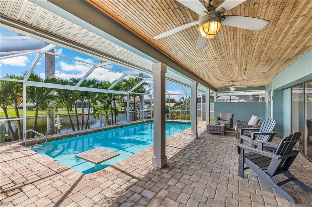 Swimming pool featuring ceiling fan, a patio, a water view, an outdoor hangout area, and a lanai
