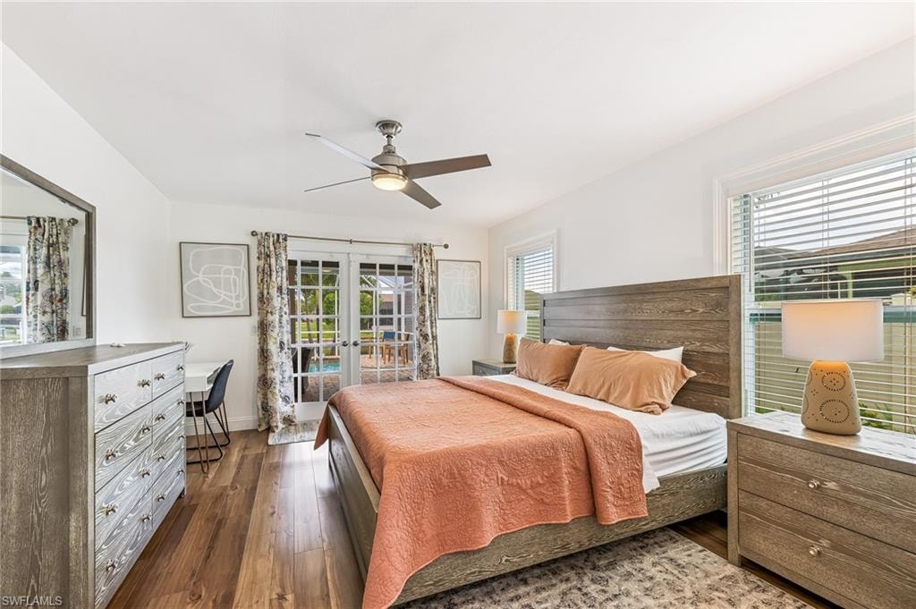 Bedroom with french doors, dark wood-type flooring, access to exterior, and a ceiling fan