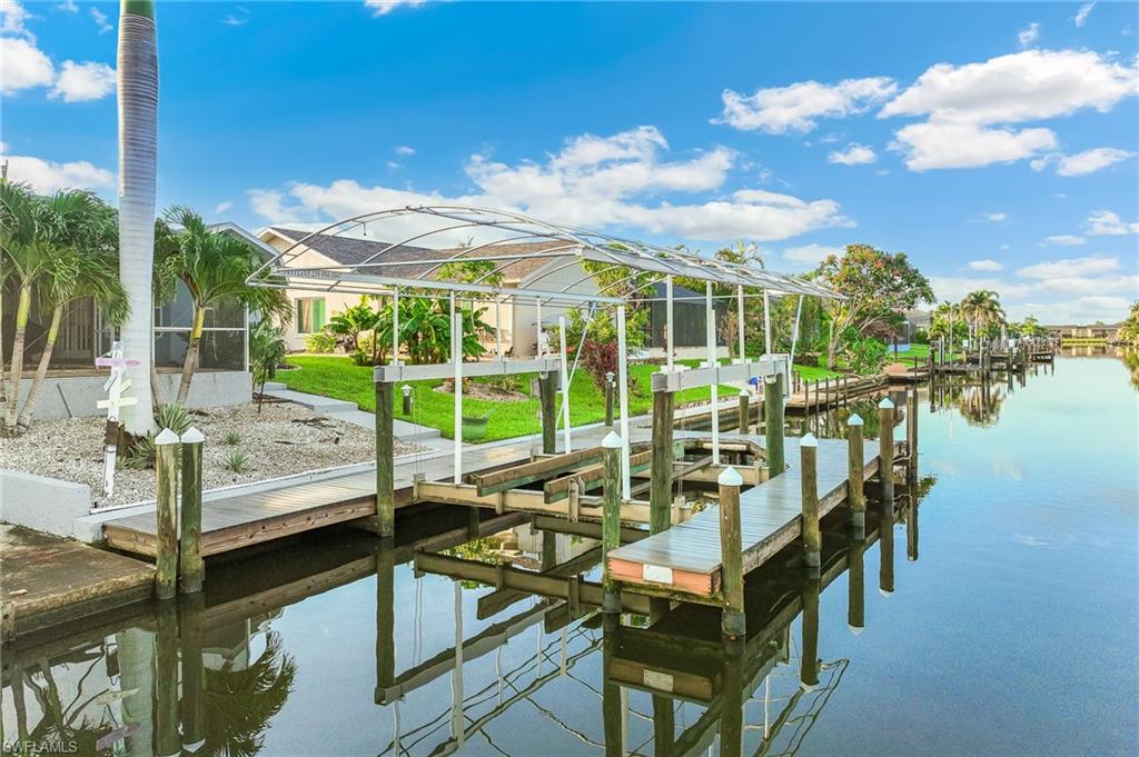 Dock area featuring boat lift, a water view, and glass enclosure