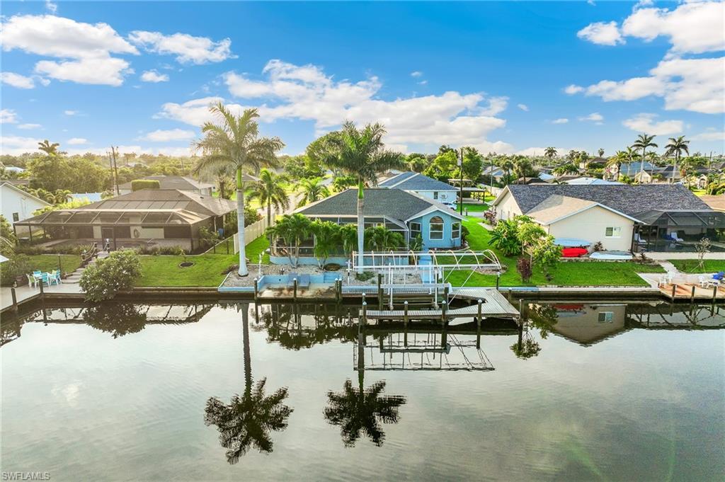 Dock with boat lift, a residential view, and a water view
