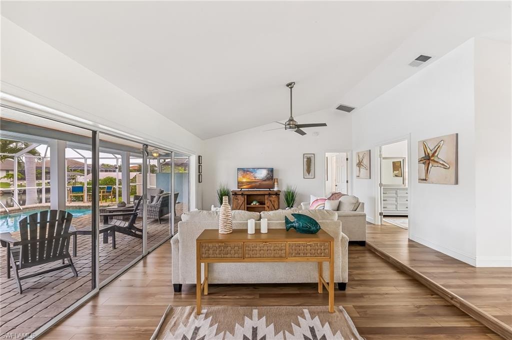 Living room featuring ceiling fan, wood finished floors, and high vaulted ceiling