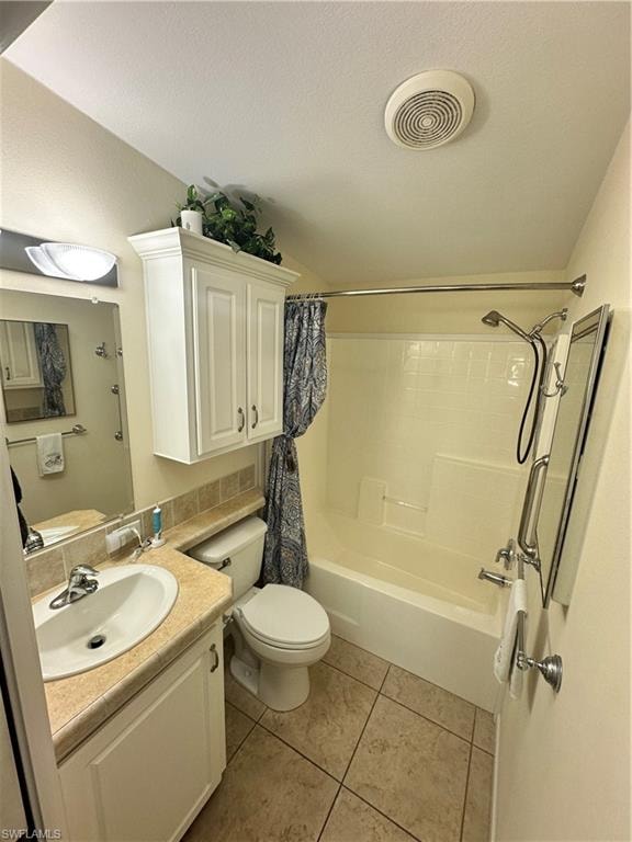 Full bath with vanity, shower / tub combo with curtain, light tile patterned floors, and a textured ceiling