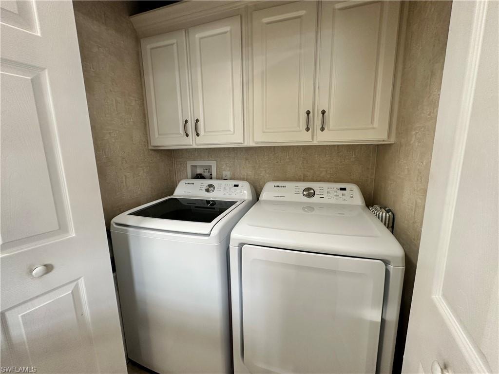 Laundry room featuring separate washer and dryer and cabinet space